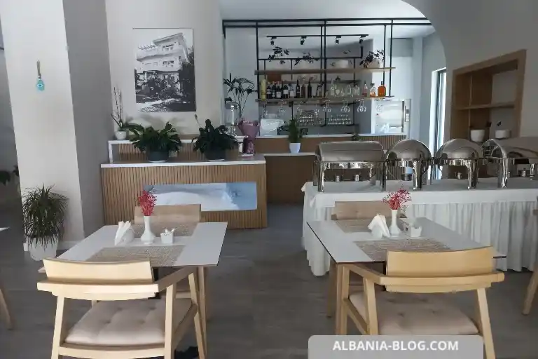 Sea Side hotel breakfast hall in Vlore with white interior, wooden chairs and bar area