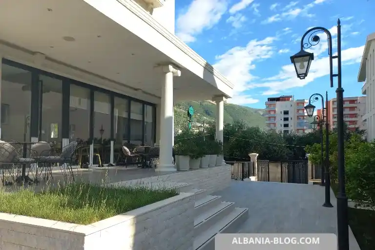 Sea Side hotel courtyard in Vlore with marble steps, tall windows, trees and Greek-Roman style architecture