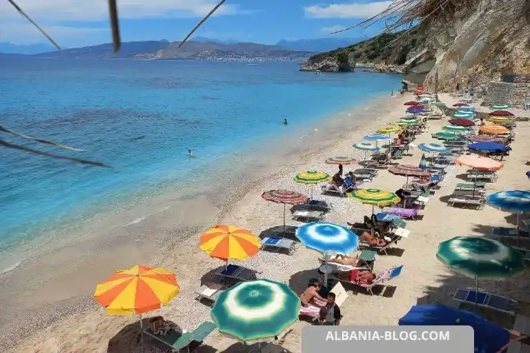 Pulebardha Beach in Ksamil, colorful umbrellas, blue sea and sandy shoreline