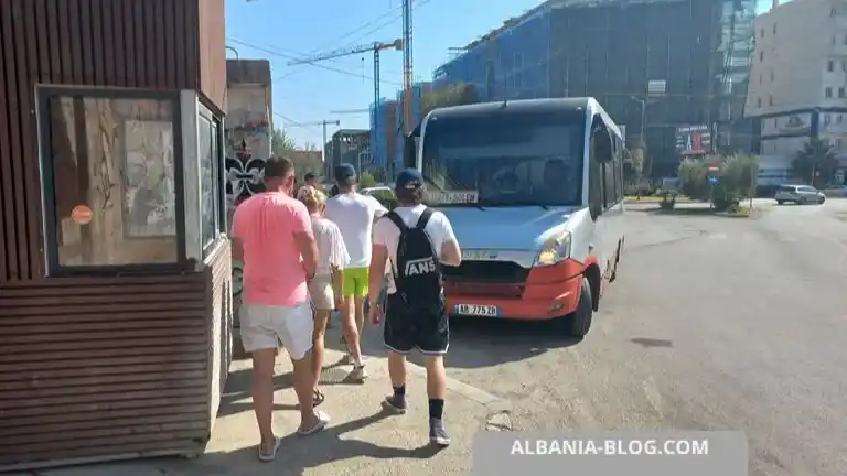 Tourists boarding a small Iveco minibus at Golem bus stop roundabout