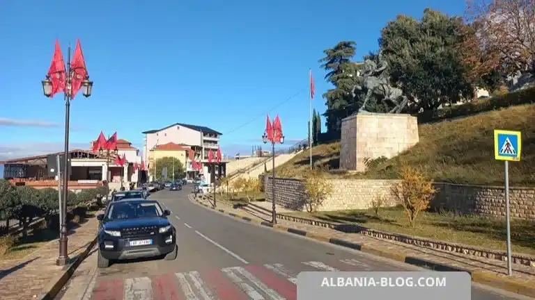 Road through central Kruja with the Skanderbeg monument and Albanian flags
