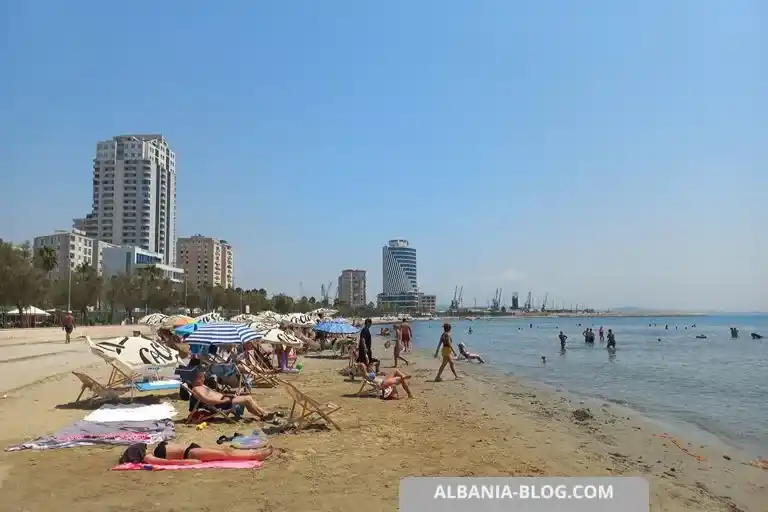 Общественный песчаный пляж в Дурресе с зонтами и современными зданиями
