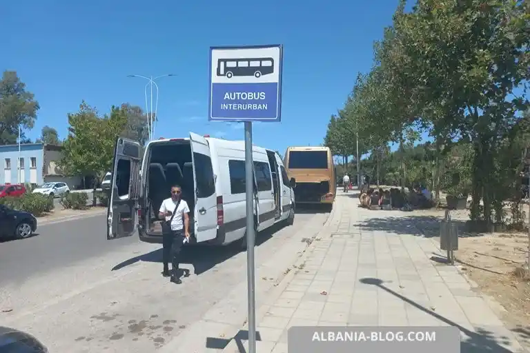 Autobus Interurban sign post at Vlore bus terminal with Mercedes minibus and waiting tourists